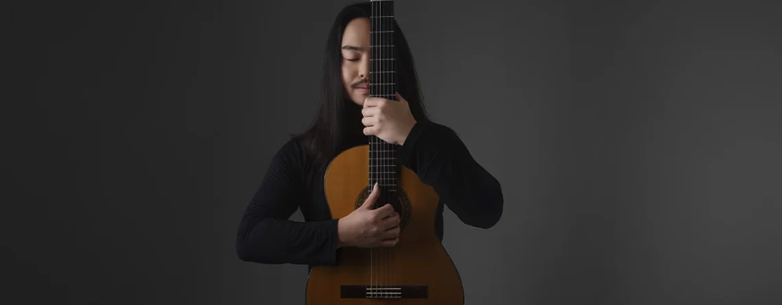 Violonista Arthur Endo abraçado ao violão, professor do Método Violão 100