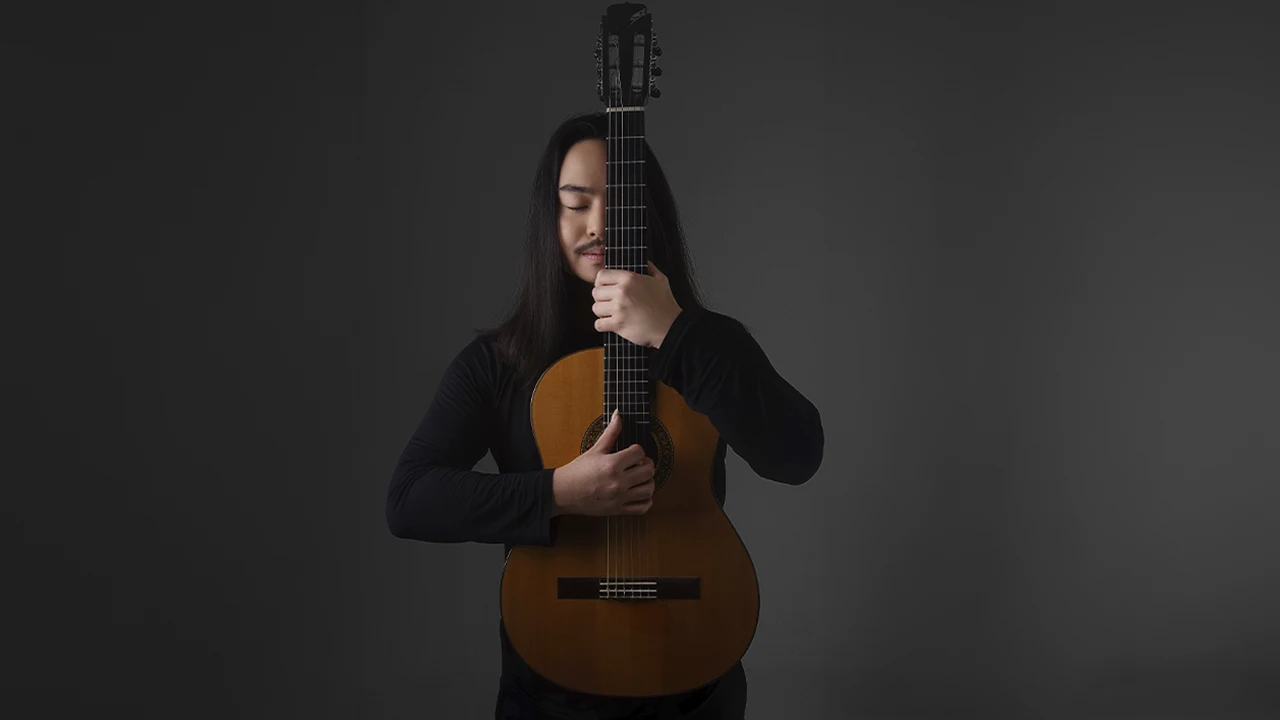 Violonista Arthur Endo abraçado ao violão, professor do Método Violão 100